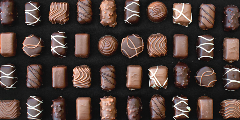 small decorated chocolates in rows as you would find in a box of chocolates.